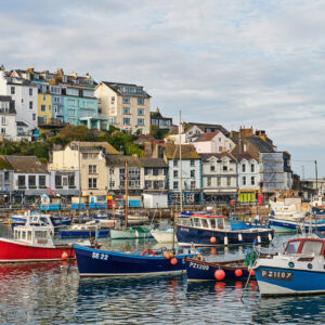 Image of Brixham, a coastal town and civil parish in the borough of Torbay in the county of Devon, UK. Image shows boats on the water and town in background.