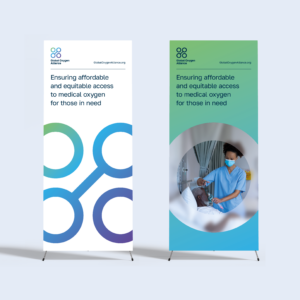 Two roll-up exhibition banners showcasing the Global Oxygen Alliance visual identity designed by 400. The banner text reads 'Ensuring affordable and equitable access to medical oxygen for those in need'.